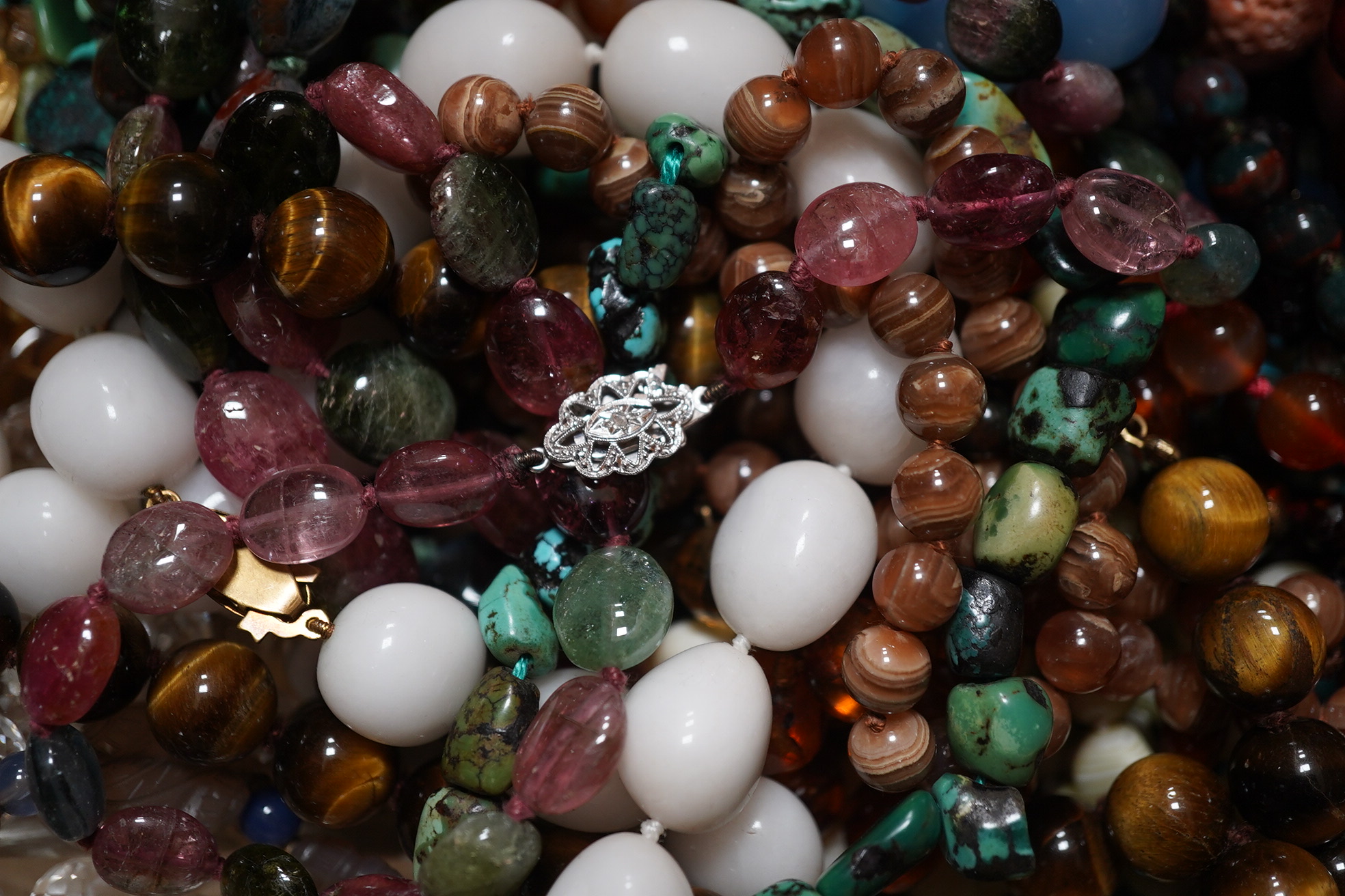 A quantity of assorted bead necklaces including, coral, various agates, turquoise cat's eye quartz, rock crystal, tiger's eye quartz, amethyst, aquamarine etc. Condition - poor to fair to good